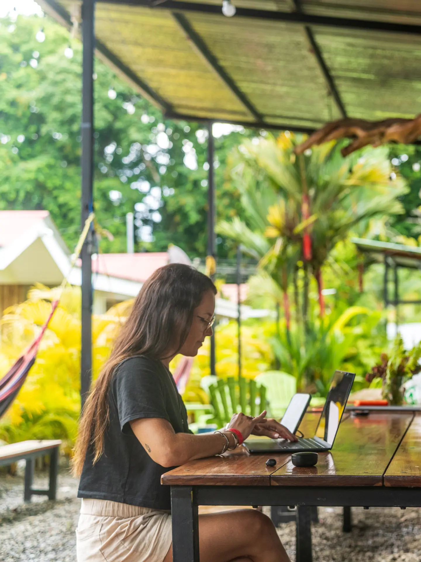 Nómada trabajando con laptop en un espacio al aire libre rodeado de naturaleza