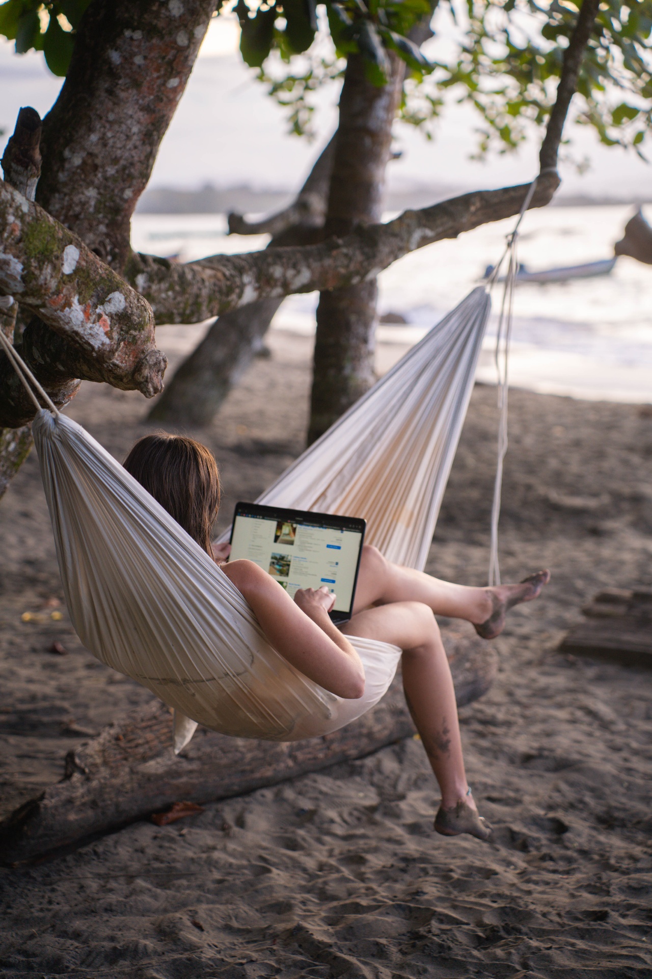 Nómade trabajando desde una hamaca en la playa
